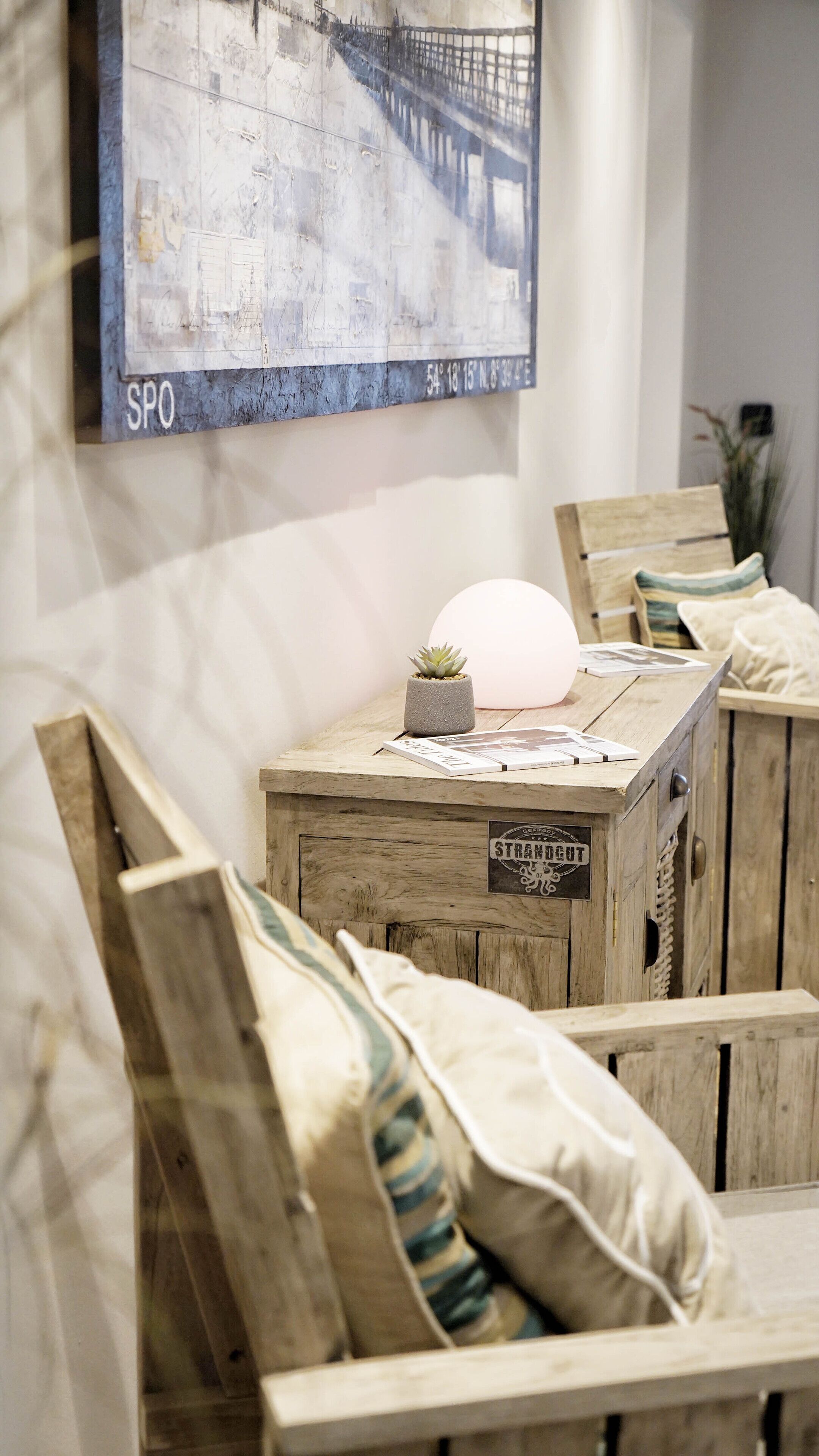 Een kamer met houten banken, een kleine plant in pot en een wandlamp.