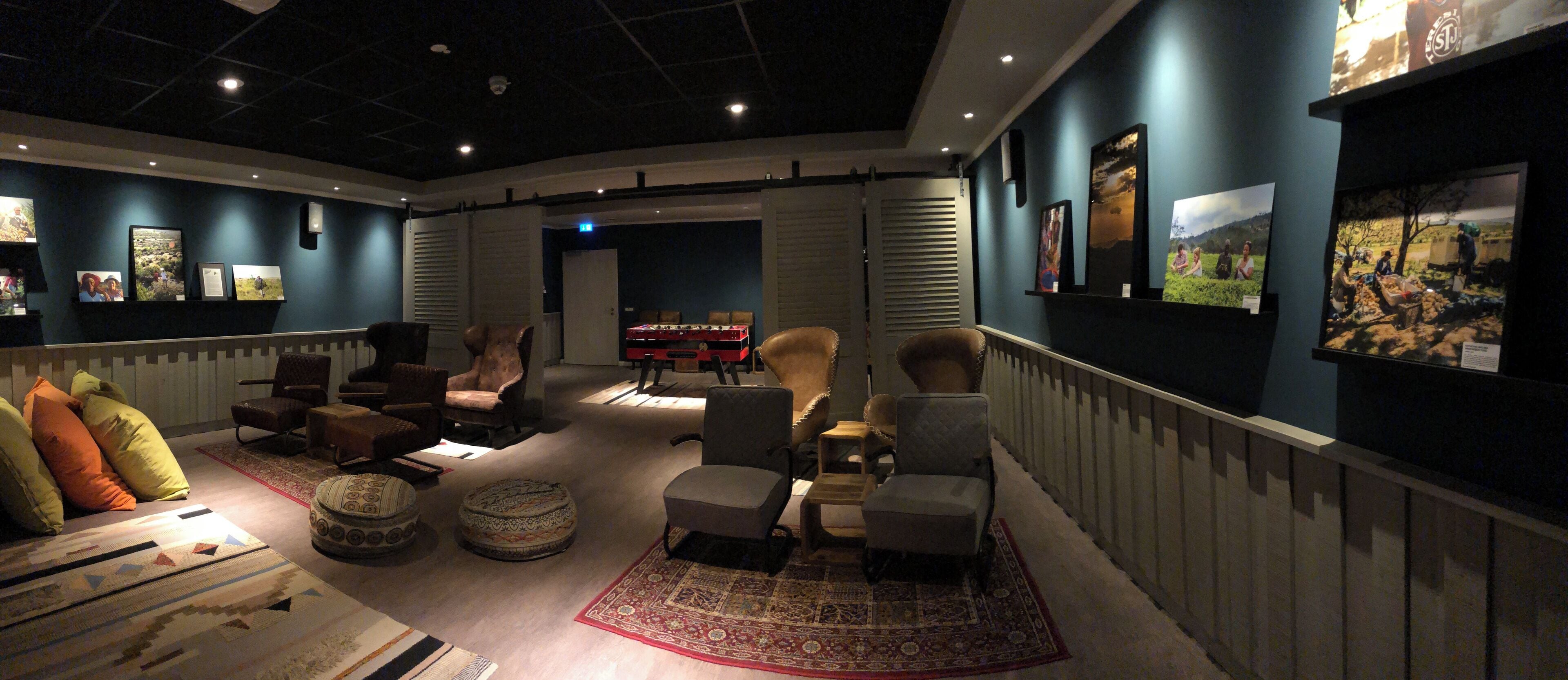 A lounge area with seating, a fireplace, and wall-mounted artwork.