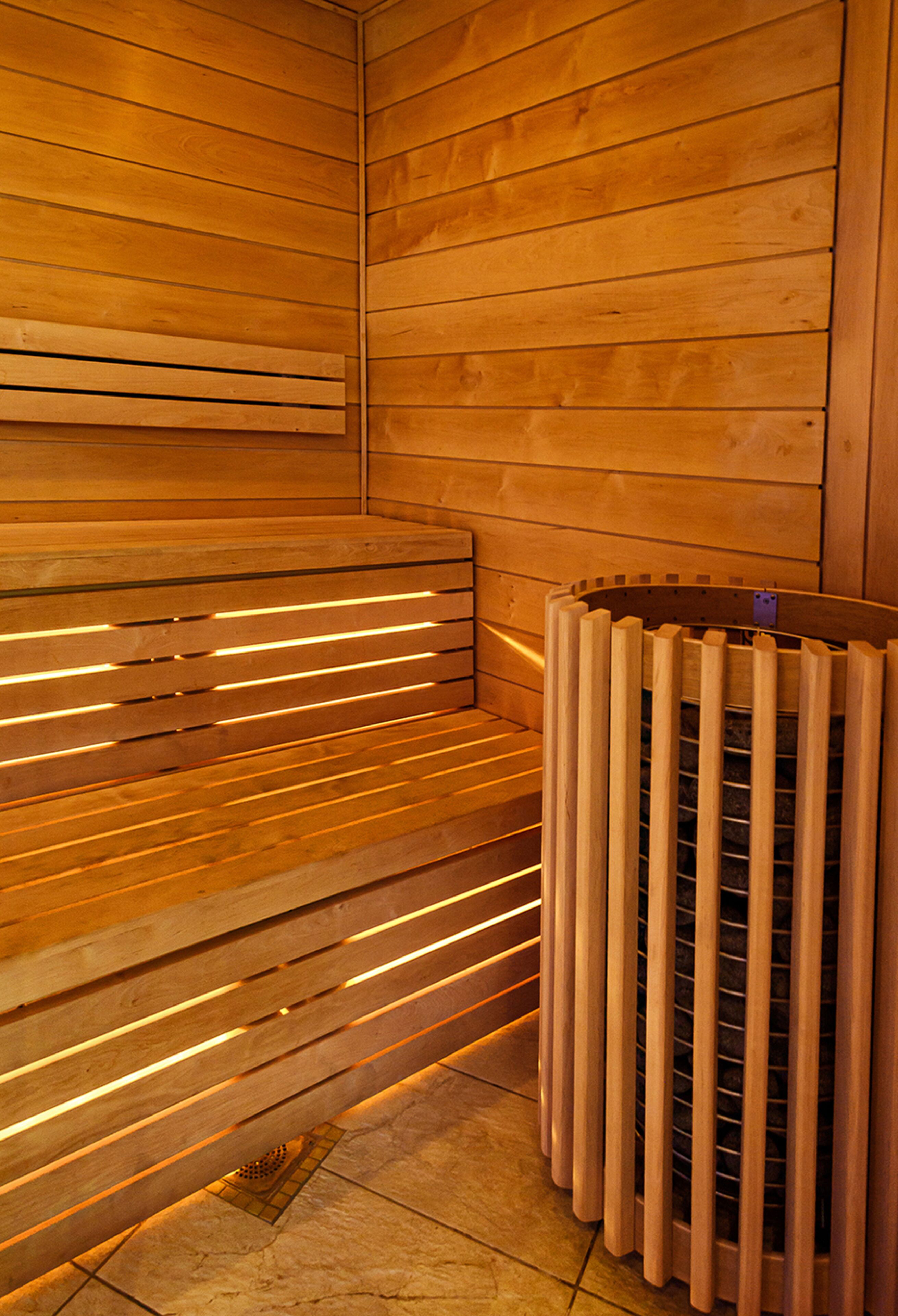 A sauna with wooden benches and a metal heating element.
