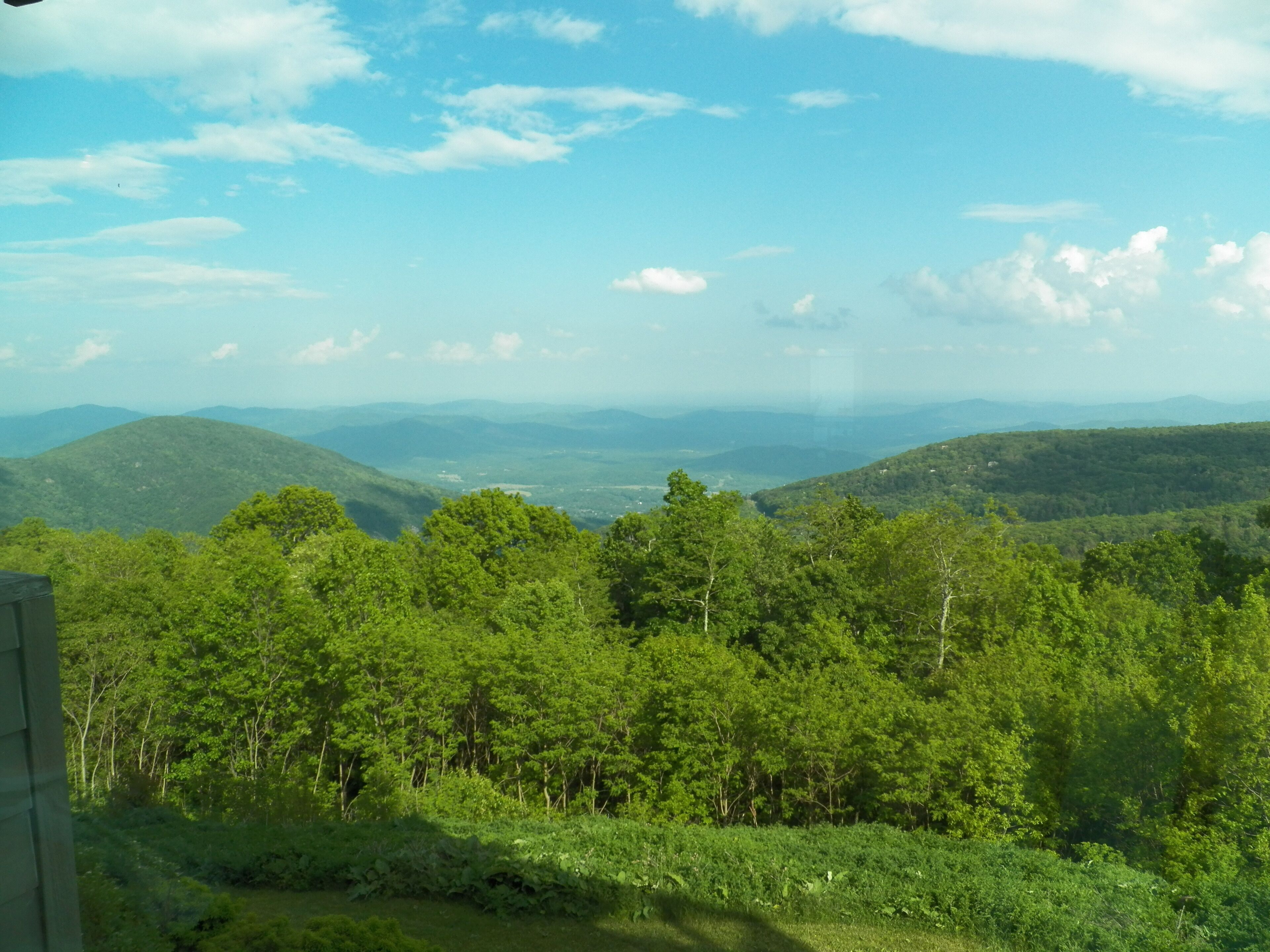 A mountainous landscape with dense green forests and a clear sky.