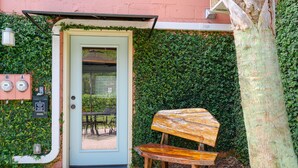 A door with a small window, a bench, and a tree. - Folly Vacation 114B Townhouse, perfect family vacation, pets welcome! (Folly Beach)
