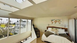 Una habitación de hotel con una cama, un escritorio y vistas a la ciudad.