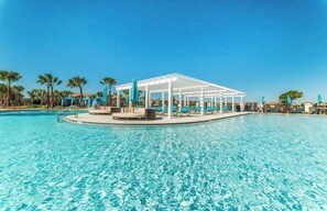 Piscina azul límpida com um gazebo branco e espreguiçadeiras.