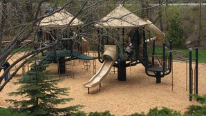 A playground with a slide, climbing structures, and a covered play area.