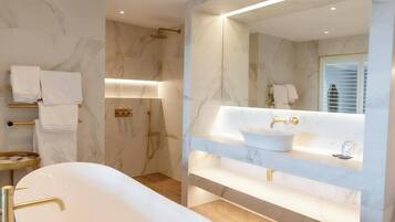 A modern bathroom with a freestanding bathtub, a large mirror, and a vanity with a sink.