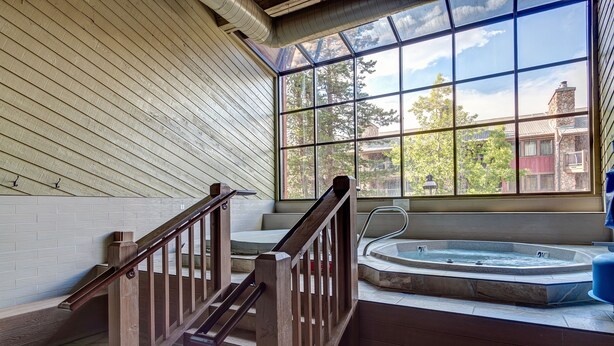 Una escalera de madera con un área de spa, que incluye una bañera de hidromasaje y vistas al exterior.