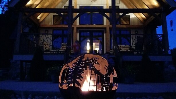 Un grande edificio in legno con un ampio atrio centrale e una scultura sferica decorativa in primo piano.