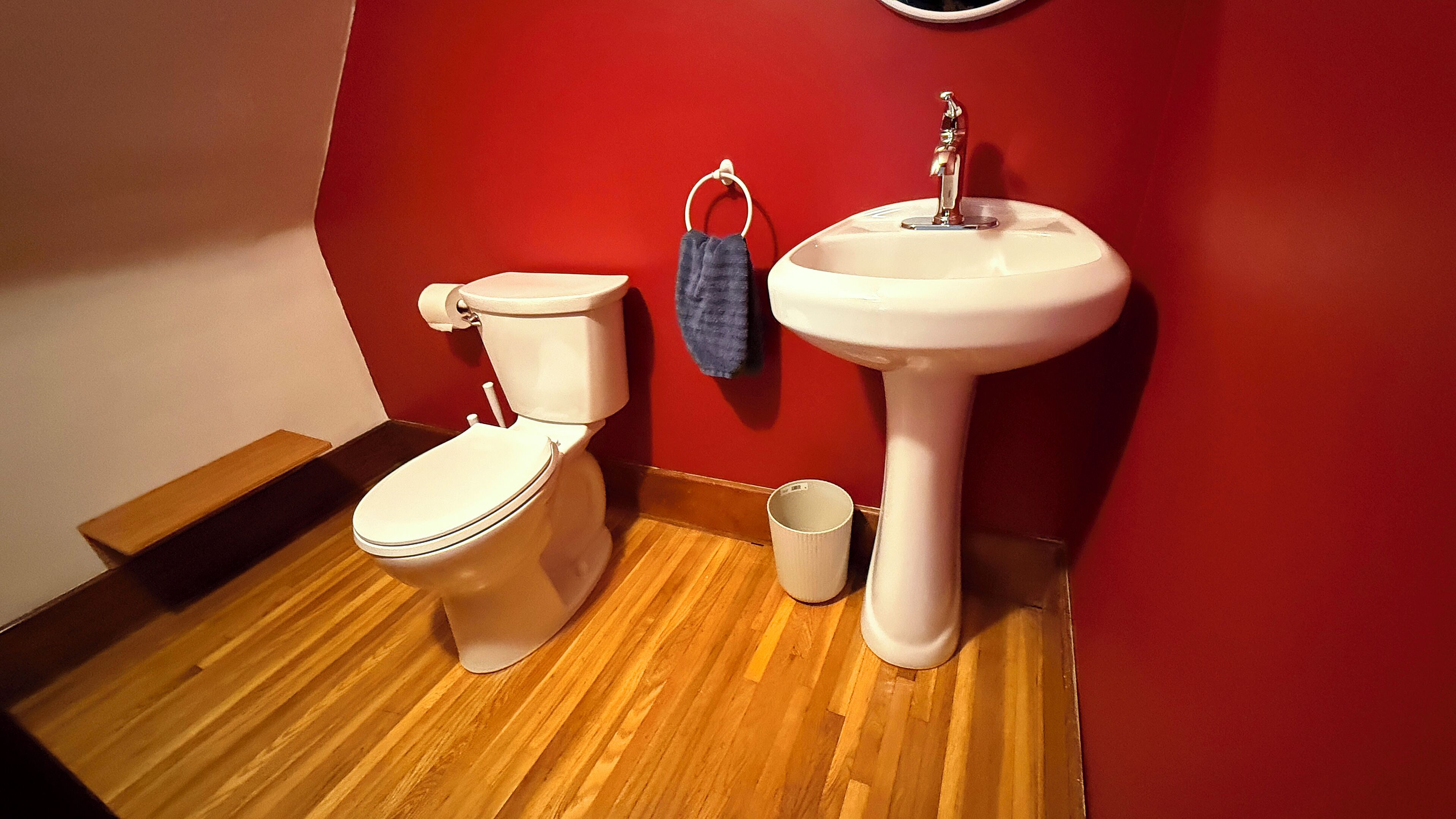 Un baño con un inodoro blanco, un lavabo y una toalla azul colgada en la pared.