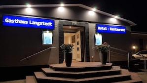 A building with a sign reading "Gasthaus Langstedt Hotel - Restaurant" and a set of outdoor stairs leading to the entrance. - Hotel Langstedt (Langstedt)
