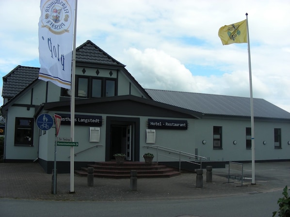 A building with a sign indicating it is a hotel and restaurant.