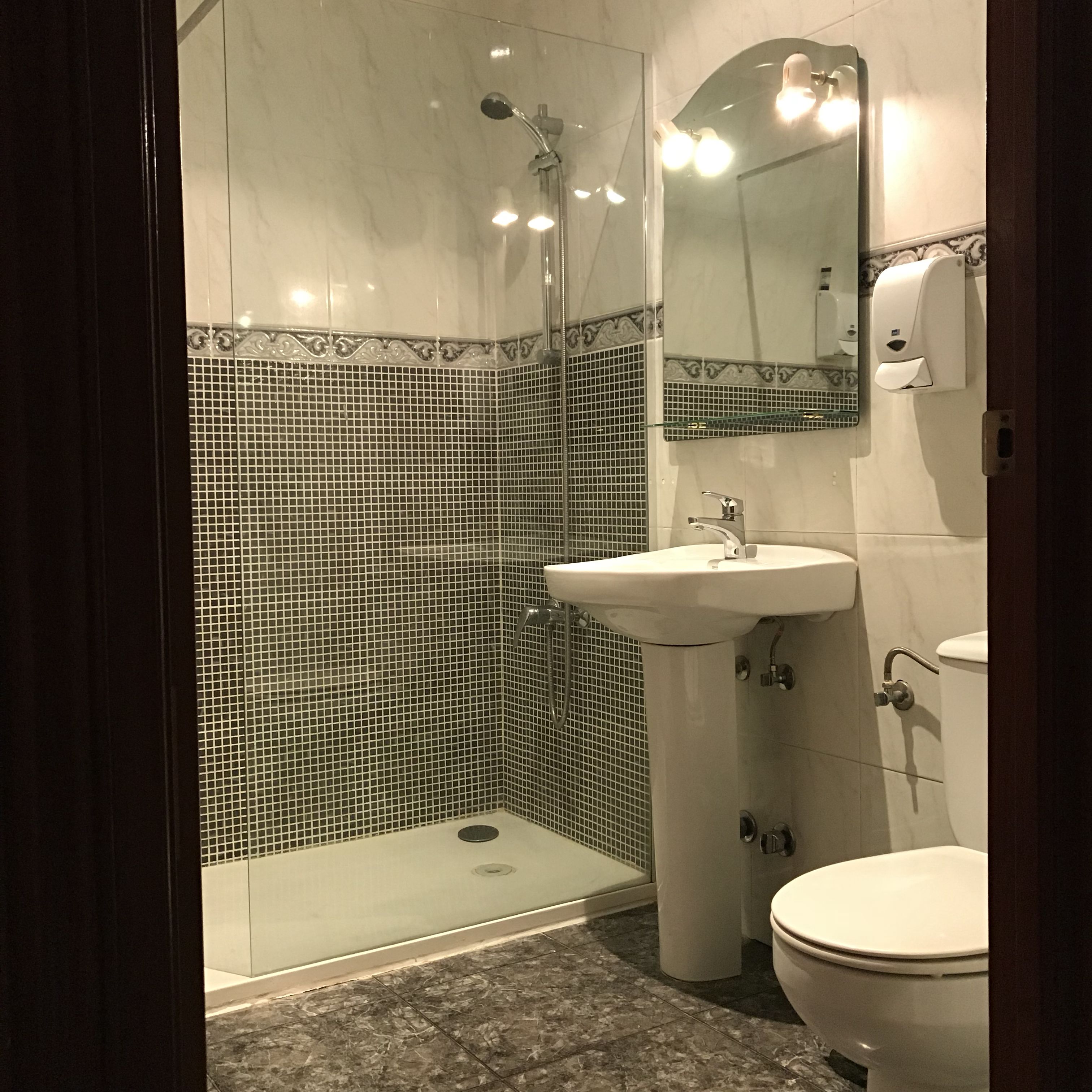 Un baño con ducha, lavamanos e inodoro.