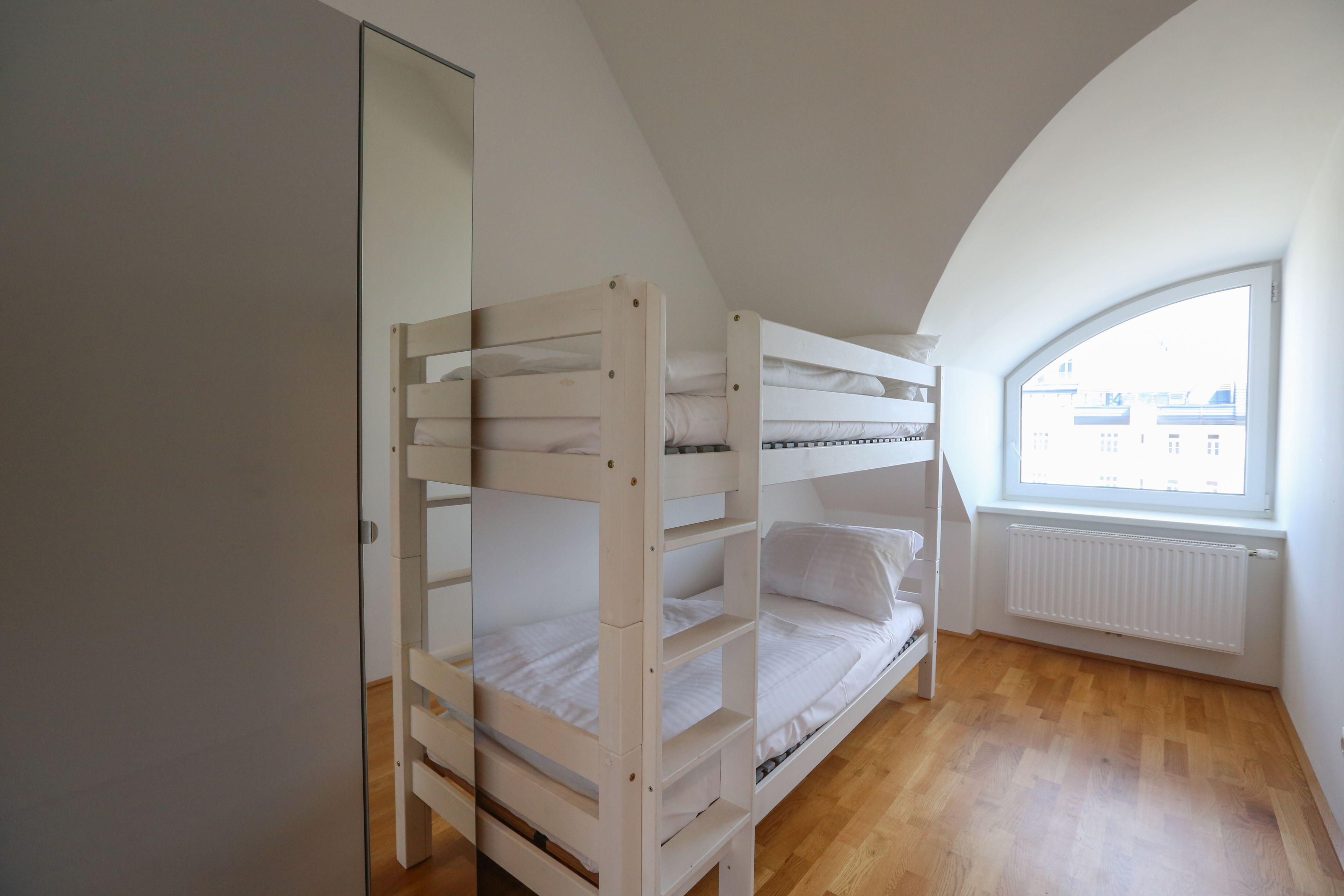 Ein Zimmer mit einem Etagenbett, einer Heizung und einem Fenster mit Blick.
