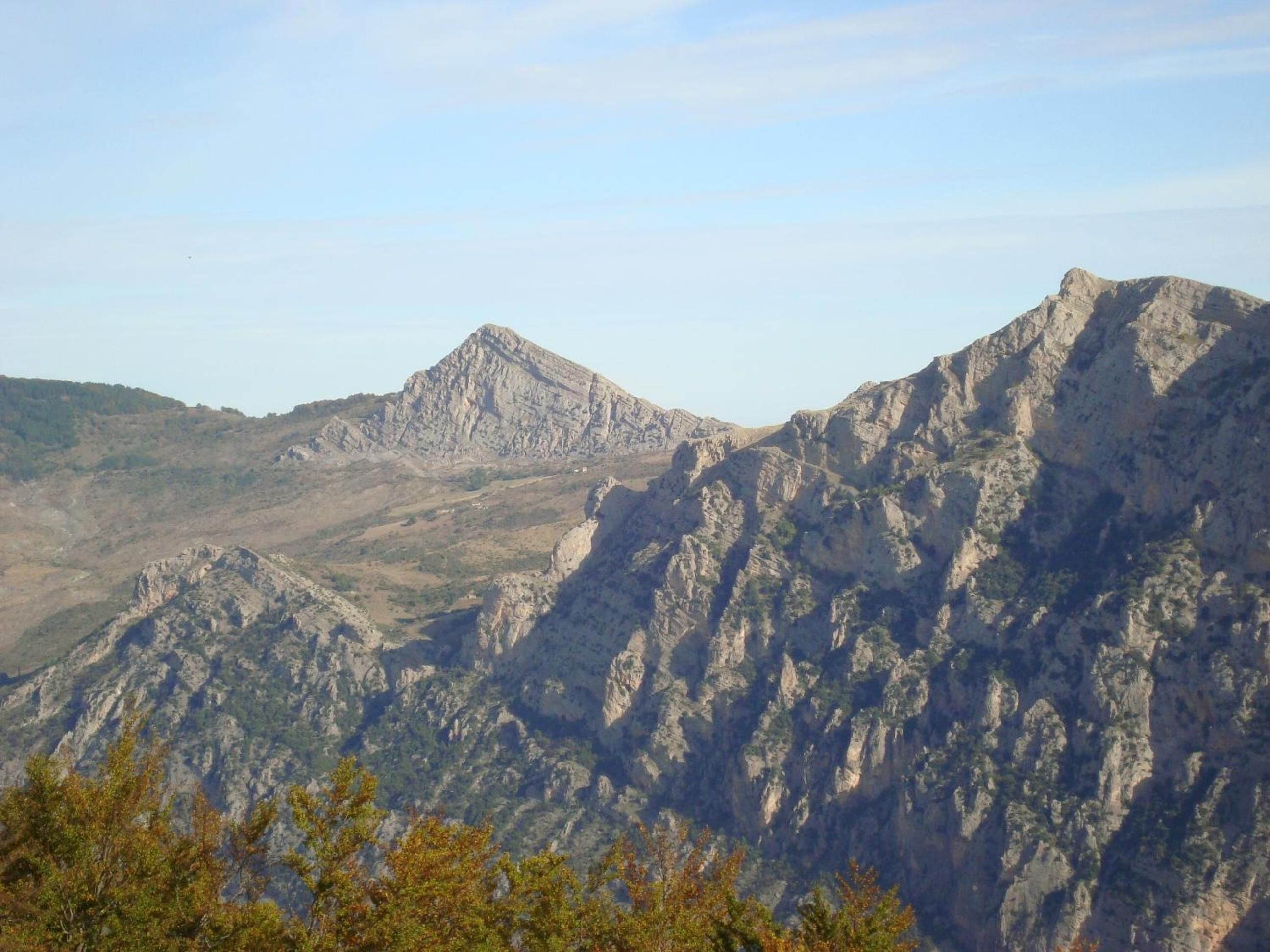 Un paysage montagneux caractérisé par un relief accidenté et une végétation clairsemée.