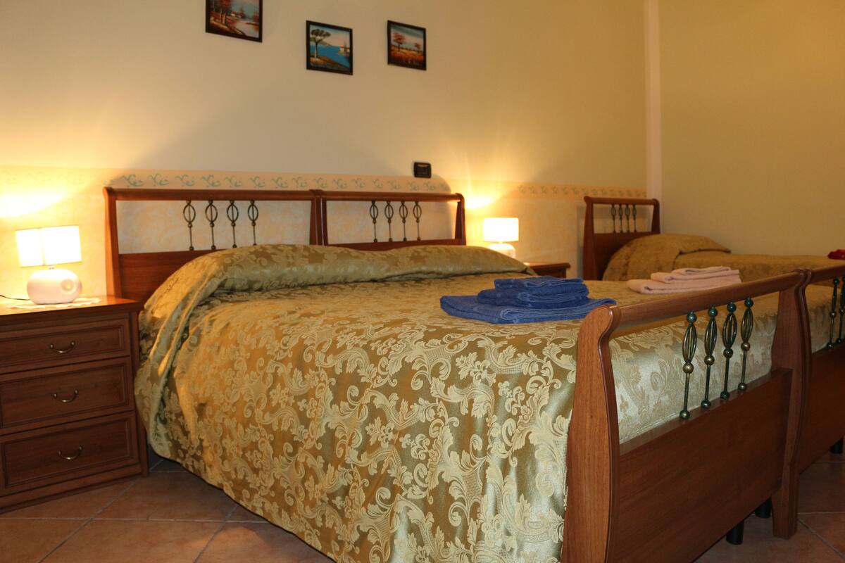 A bedroom with a wooden bed, two bedside tables, and a nightstand.