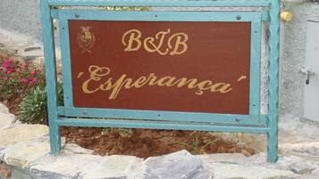 A sign with "B&B Esperanza" written on it, mounted on a stone wall with a blue frame.