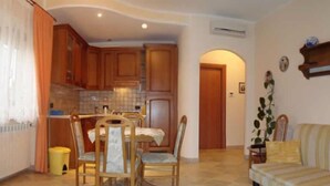 A compact living space with a dining area, kitchen, and a sofa. - B&B Esperanca (Frascineto)
