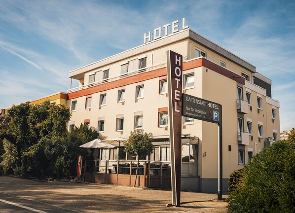 A hotel building with a sign indicating a parking area. - Gartenstadt Hotel (Ludwigshafen)