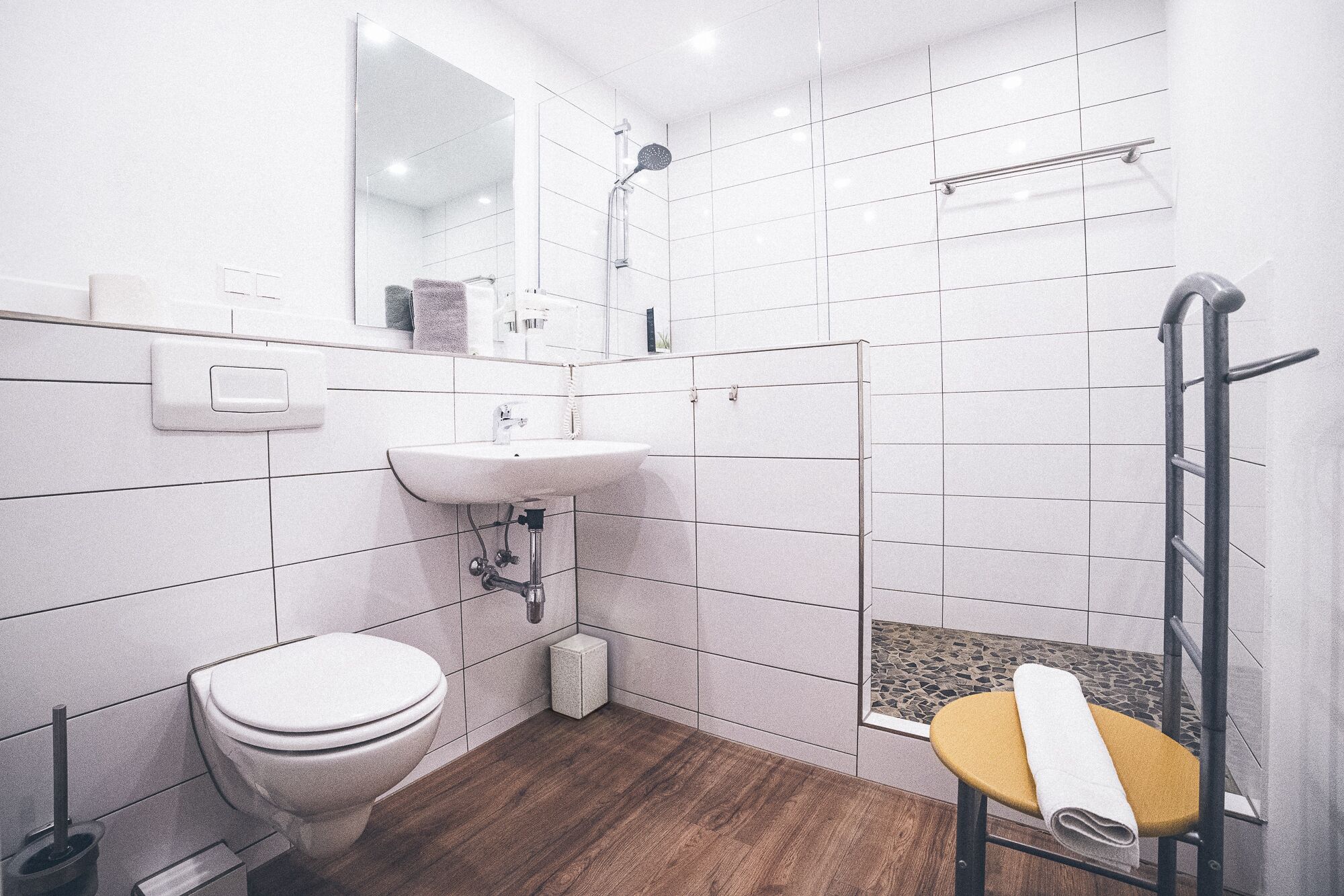 A modern bathroom with a toilet, sink, and shower.