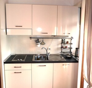 Full-sized fridge, stovetop, espresso maker, cookware/dishes/utensils
