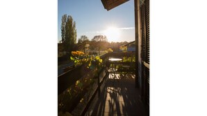 A balcony with a view of a garden and trees, a table, and chairs. - Agriturismo & Scuderia Fano's Farm (Suno)