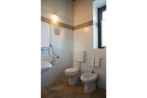 A bathroom with a toilet, bidet, and sink.