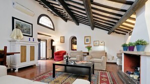 Un salón amplio con chimenea, una mesa de centro y un sillón rojo.