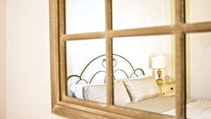 Un dormitorio con cama, almohadas, una mesita de noche y una lámpara.