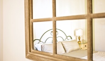 Una camera da letto con un letto, cuscini, un comodino e una lampada.