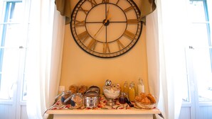 Un reloj de pared con números romanos, un estante con frascos, botellas y un bol de pasteles.