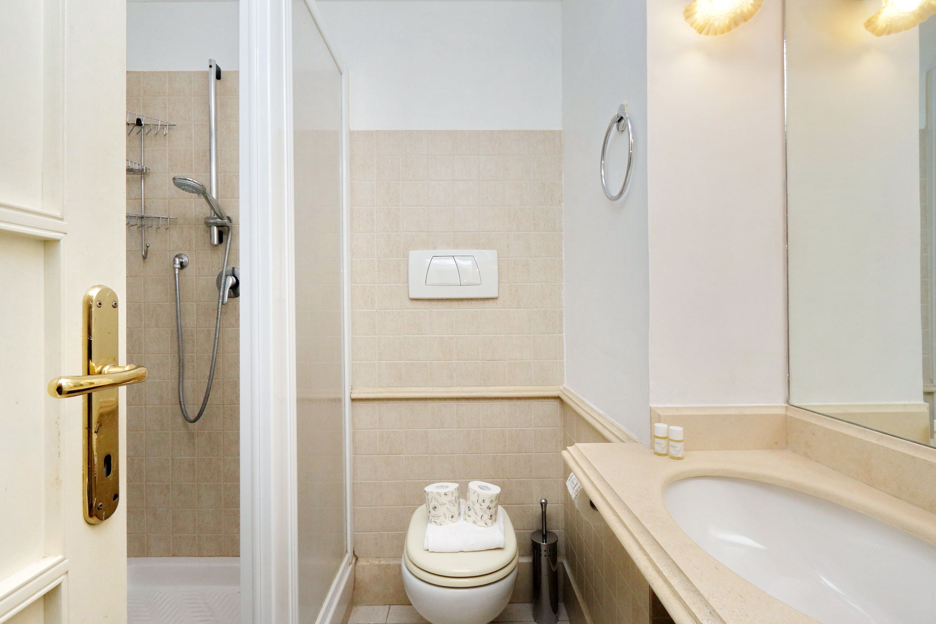 A bathroom with a toilet, shower, and sink.