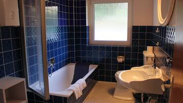 Un baño con bañera, inodoro y lavabo.