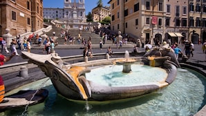 A public square with a fountain, steps leading to a church, and people walking around. - Bufalo - WR Apartments (Rome)