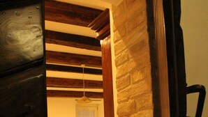 A room with a bed, a small table, and a brick wall. - B&B Porta Santa Lucia (Fermo)