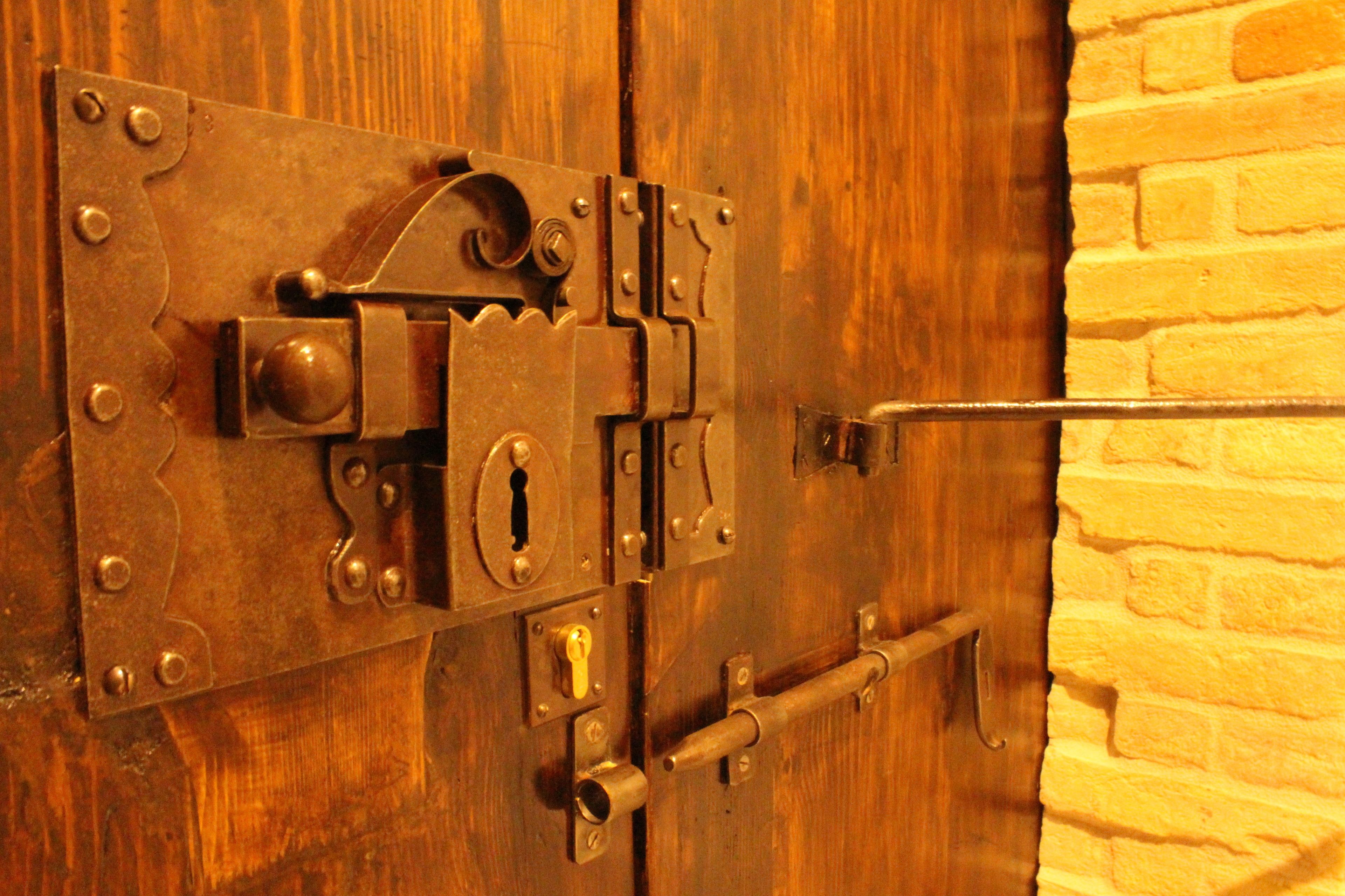 Una porta in legno con un chiavistello metallico e una serratura.