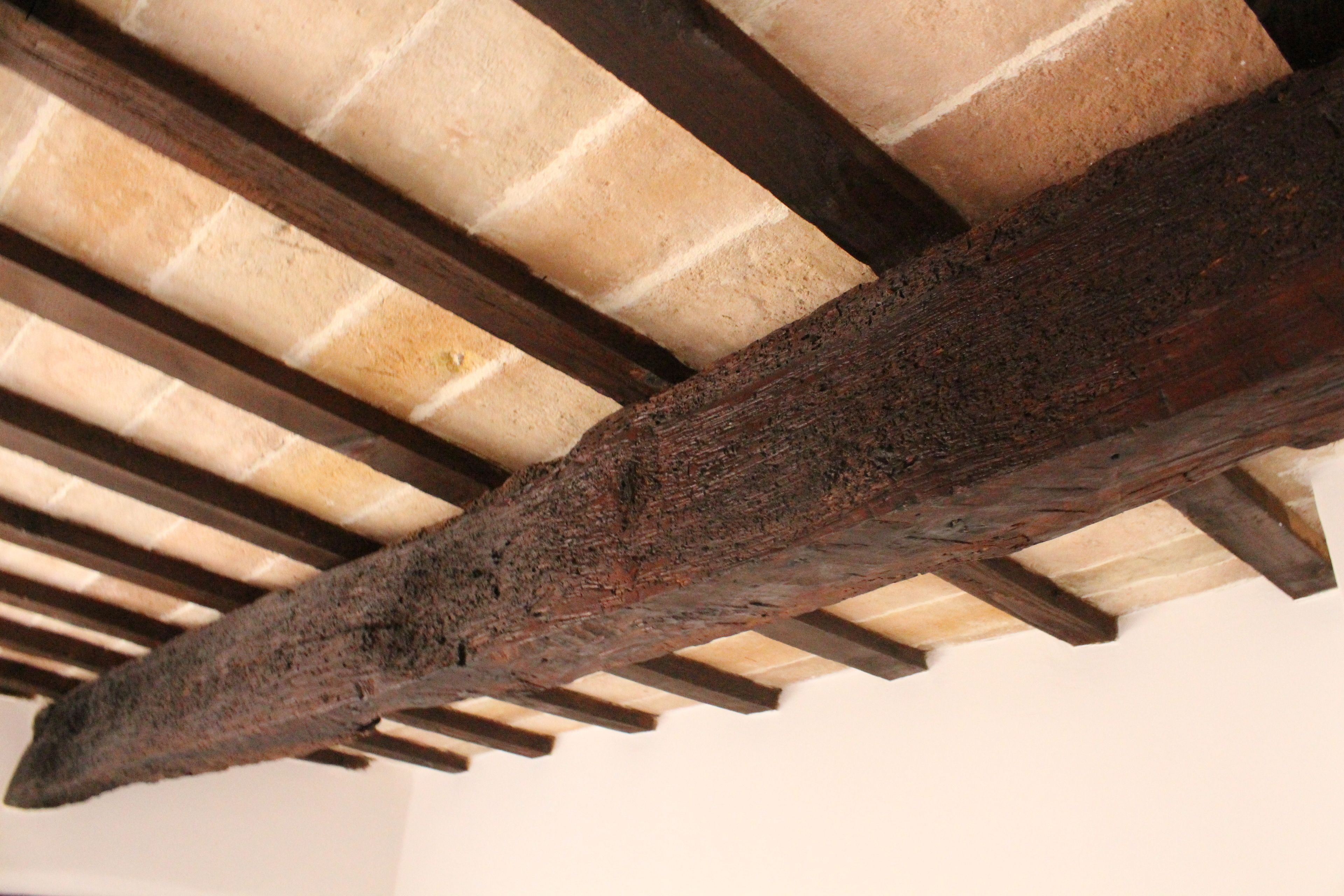 A wooden beam structure with a concrete ceiling.