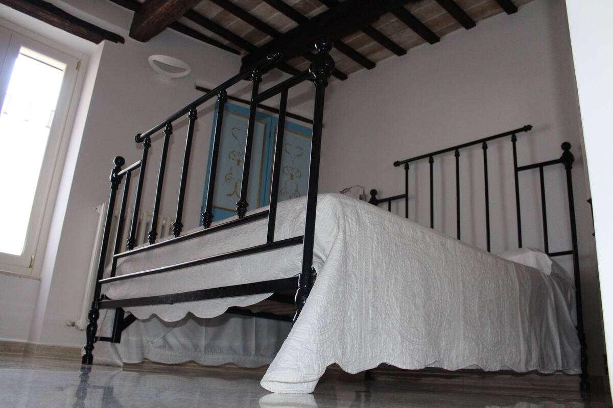 A room with a bed, a window, and a door.