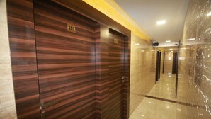 A hallway with wooden doors numbered 101 and 102, leading to rooms. - Hotel Alfa International (Mumbai)