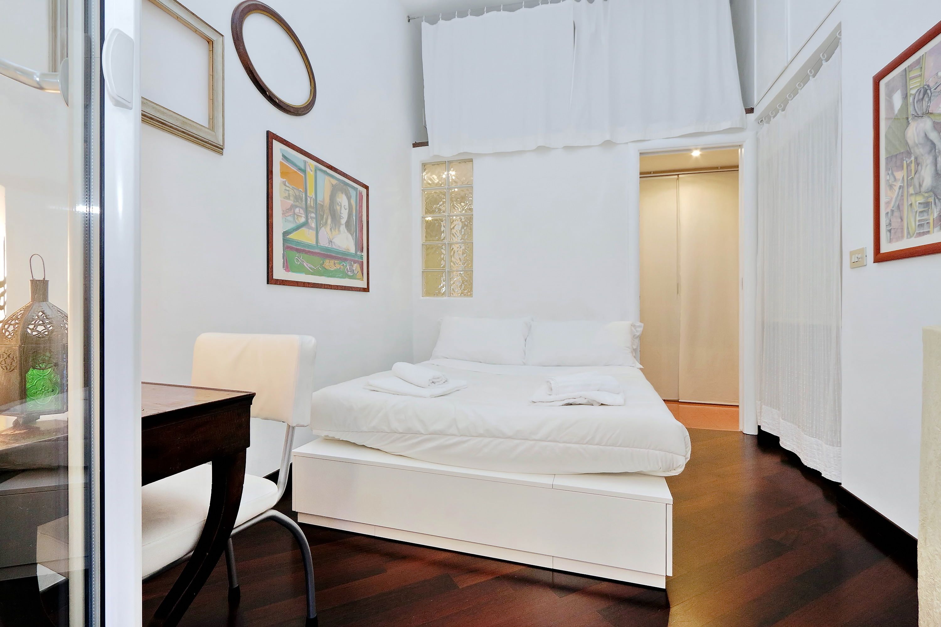 A modern bedroom with a bed, a desk, and a chair.