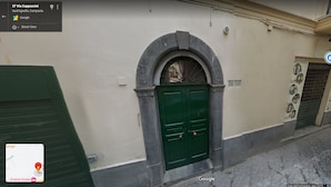 A street view of a building with a green door and a sign indicating 'Grand Hotel'. - Casa Ninà (Sant'Agnello)