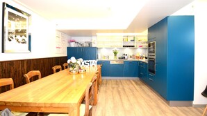 Una cocina moderna con armarios azules, una mesa de comedor de madera y sillas.