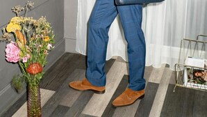 Un hombre con traje azul utilizando un quiosco de autoservicio en una habitación de hotel.