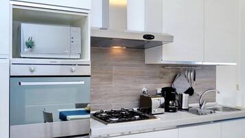 Departamento, 2 habitaciones | Cocineta privada | Refrigerador con congelador, microondas, horno y parrilla de estufa