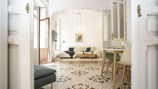 A living room with a patterned floor, a sofa set, a dining table with chairs, and a painting on the wall. - Singular Stays Ms Rogers (Valencia)