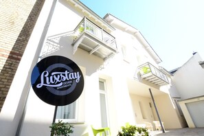 A building with a sign reading "Luxstay Design Apartments."