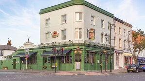 A green building with multiple windows and a sign that reads "RAMPUBC". - Black Lion (Surbiton)