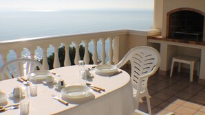 A table set for dining with a view of the sea.