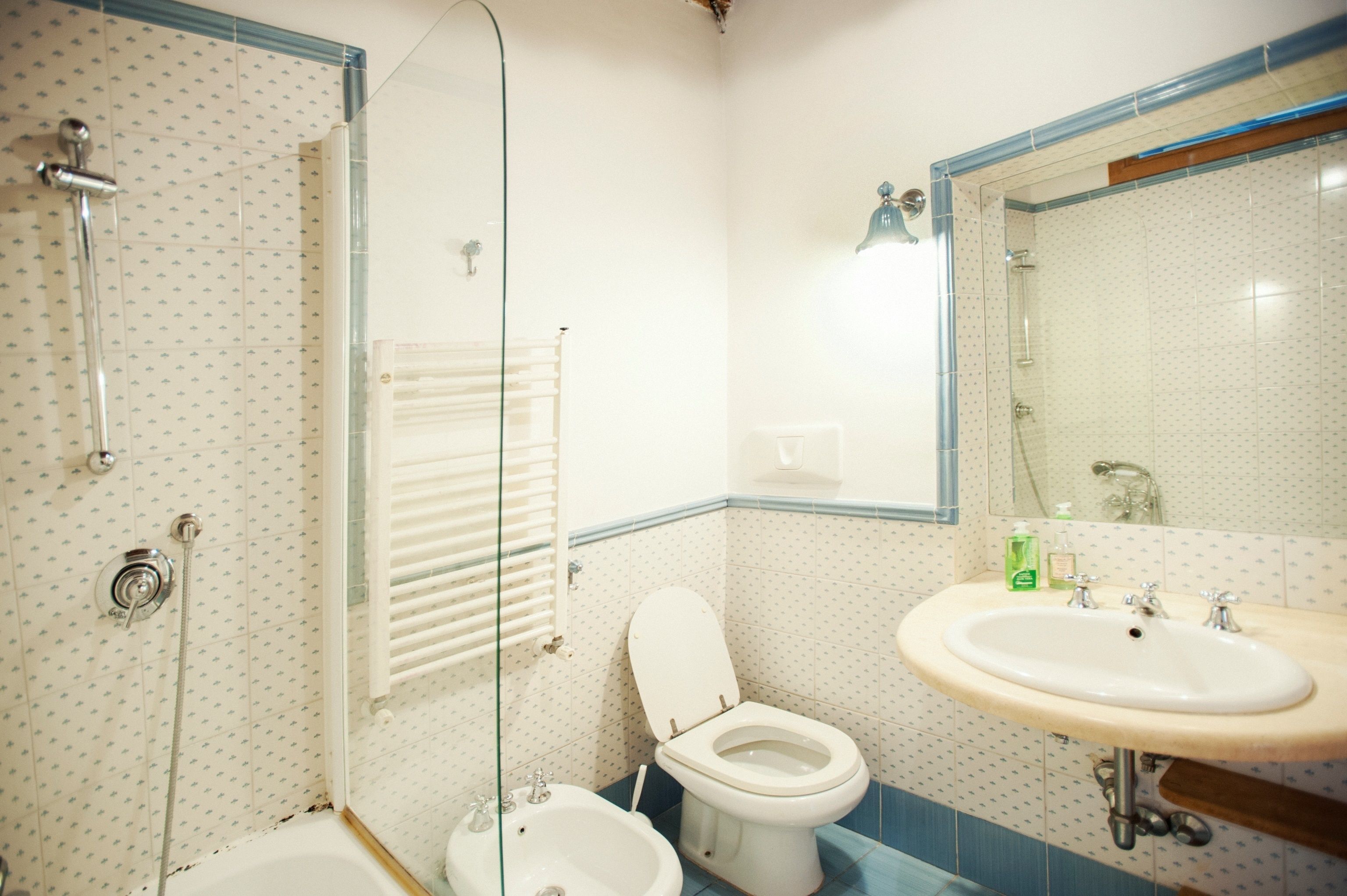 Un baño con ducha, inodoro, bidé y lavamanos.