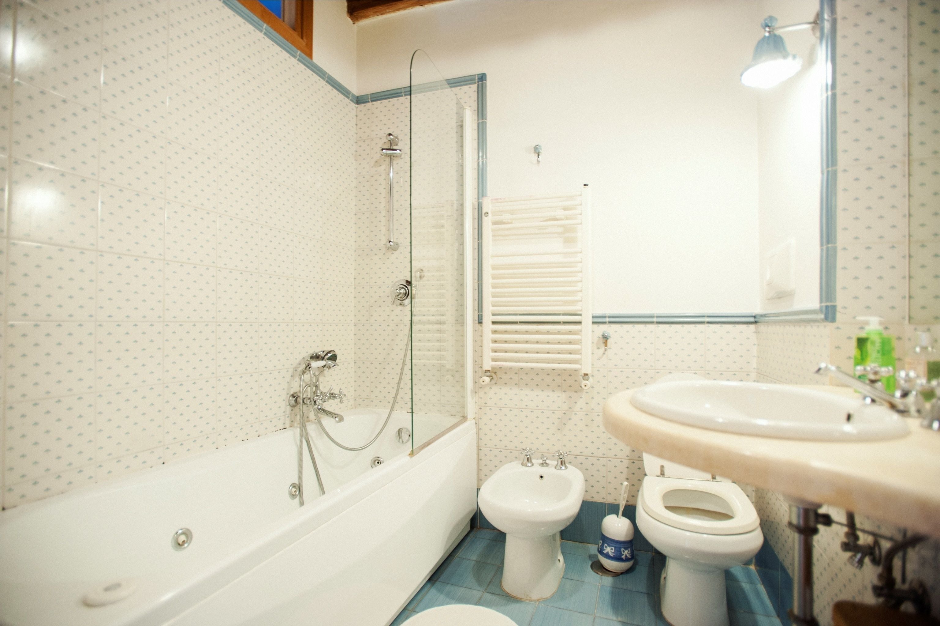 Un baño con bañera, bidé, inodoro y lavamanos.