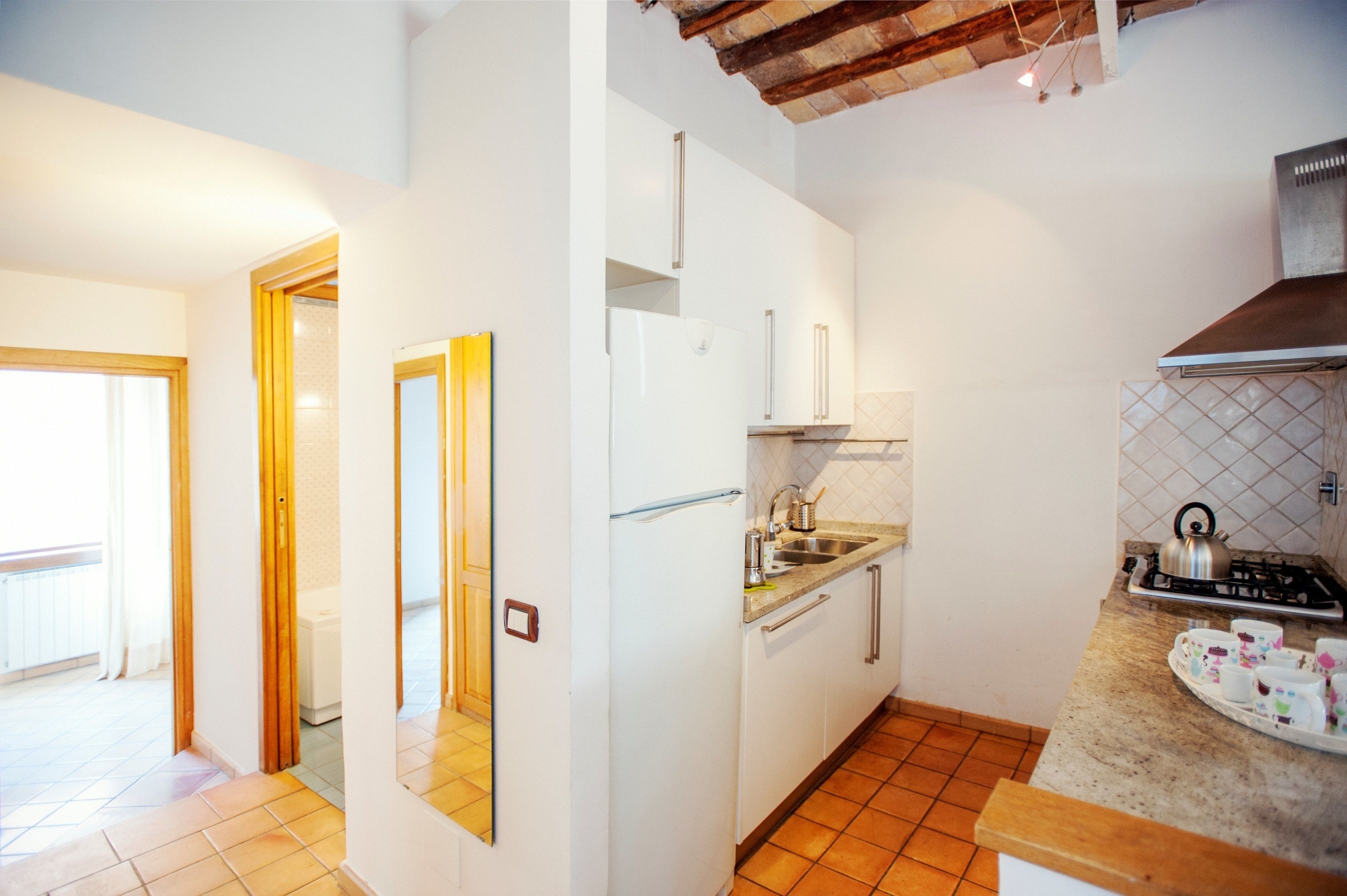 A modern kitchen with white cabinets, a built-in oven, and a gas stove.