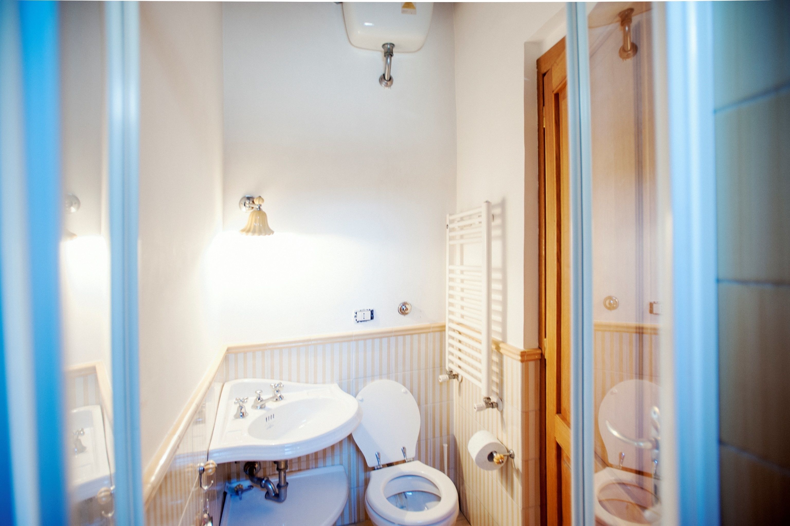 A bathroom with a double sink, toilet, and shower.